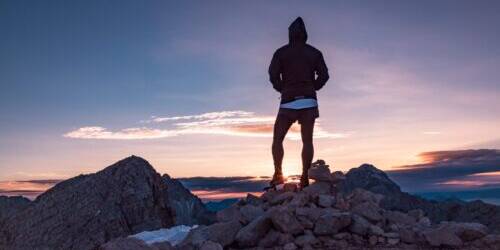Person standing on rock formation during golden hour