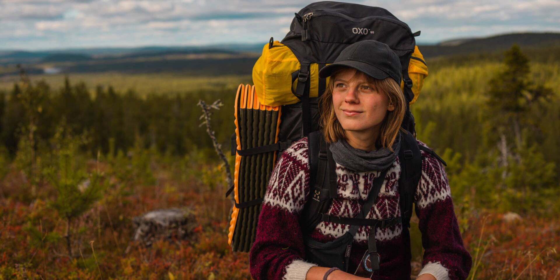 Huvudbild för kursen. Bild på en av deltagarna som är ute i vildmarken en höstdag.